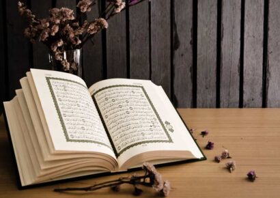Quran on the table with flower spread around it
